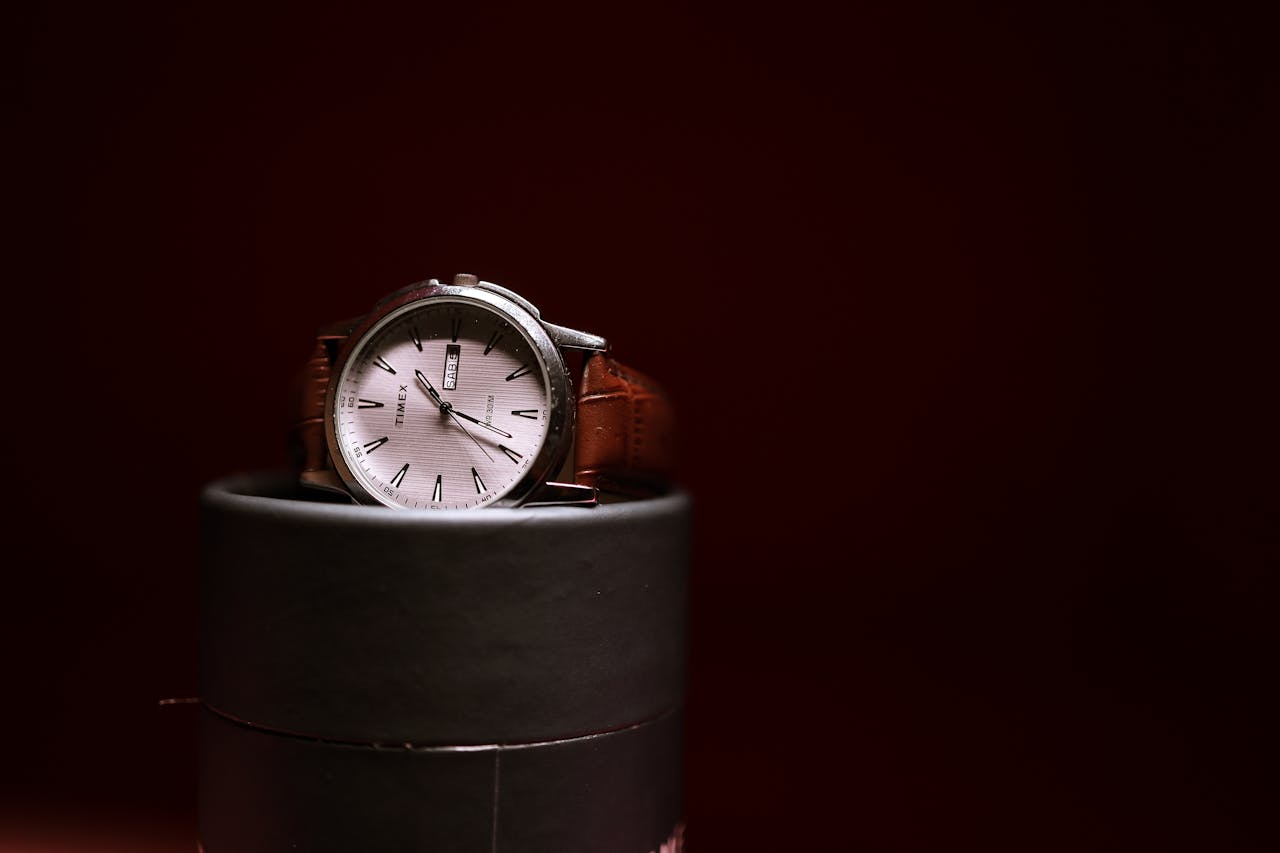 Stylish Timex watch with a brown leather strap elegantly displayed on a cylindrical stand.